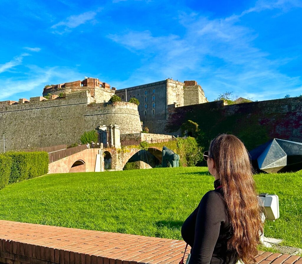 Una persona de espaldas con la Fortaleza de Priamar en Savona, de fondo